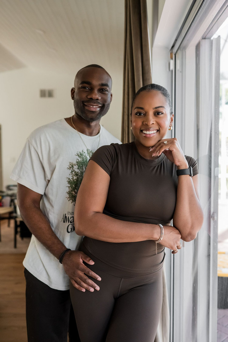 Couple standing together by a window at home, smiling