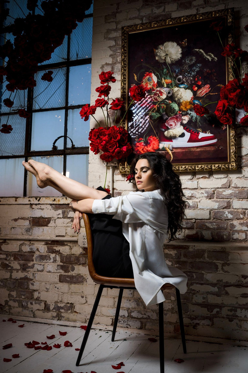 Woman surrounded by a large arrangement of roses and dried flowers
